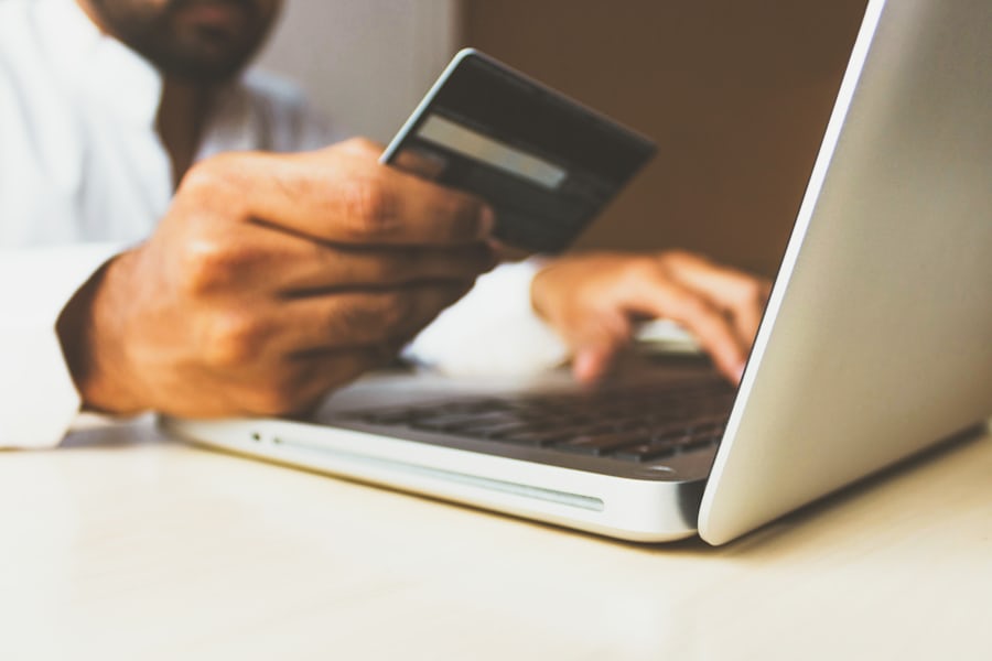 Laptop dengan kartu bank untuk transaksi perbankan daring