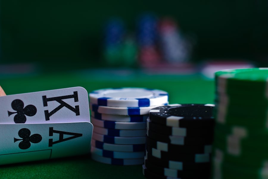 Kartu poker terbuka dan tumpukan chip di atas meja berbulu hijau
