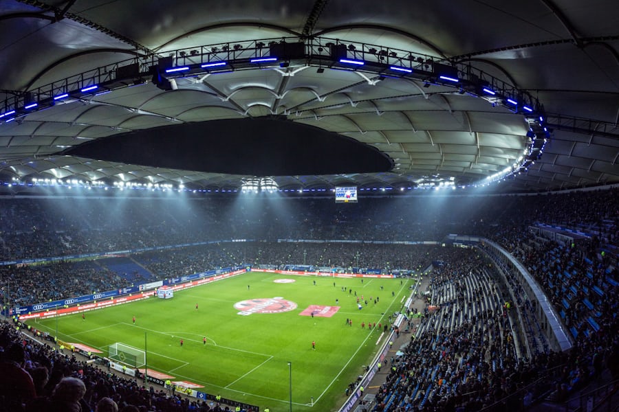 Stadion sepak bola malam hari dengan lampu sorot menyala